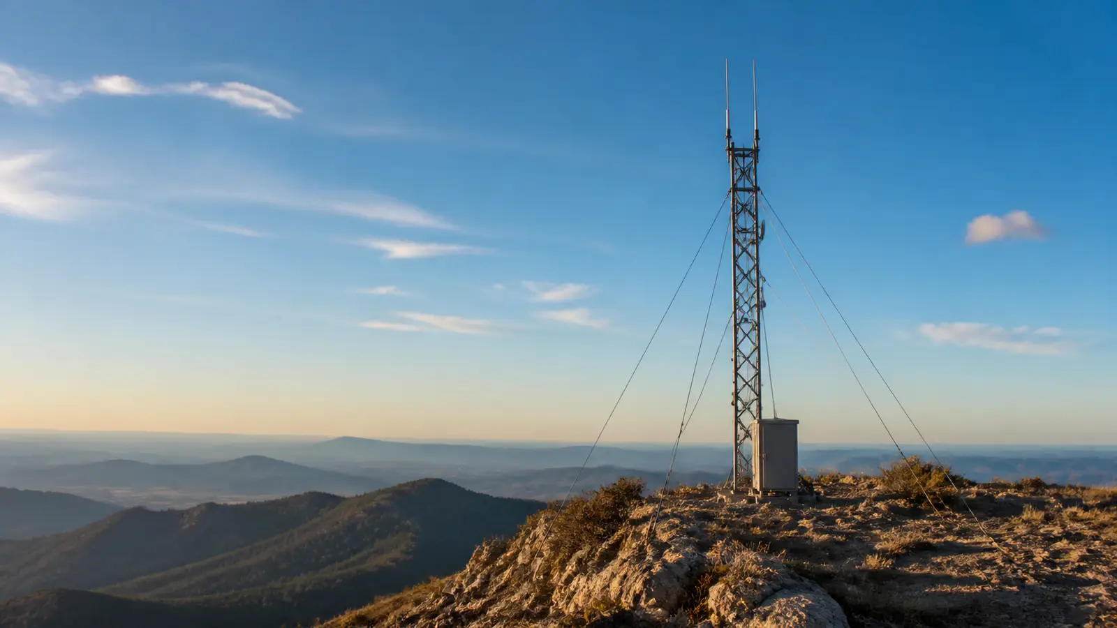 A GMRS repeater antenna mounted on a tower on a ridge, valley visible far below